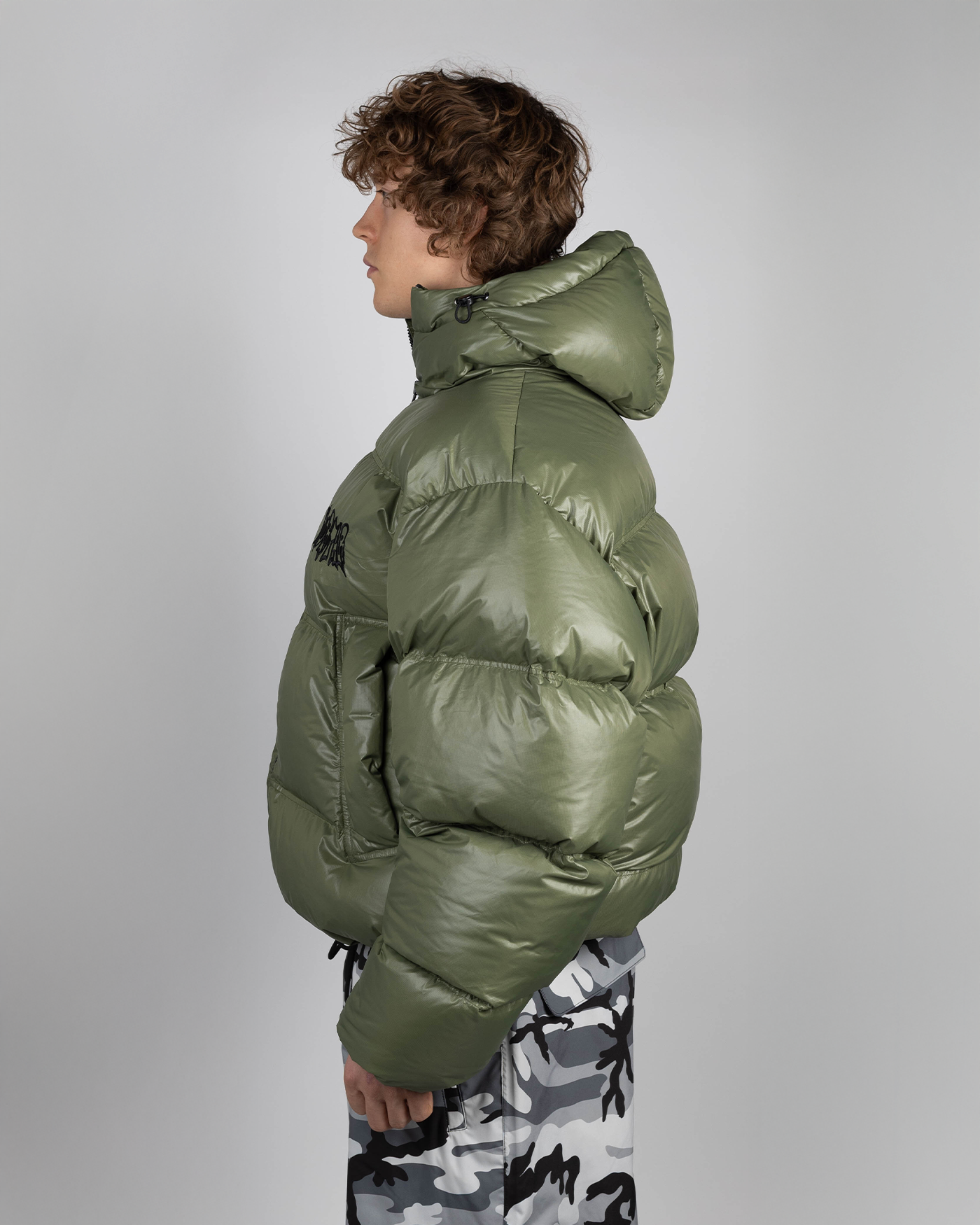 Green puffer jacket side view on model
