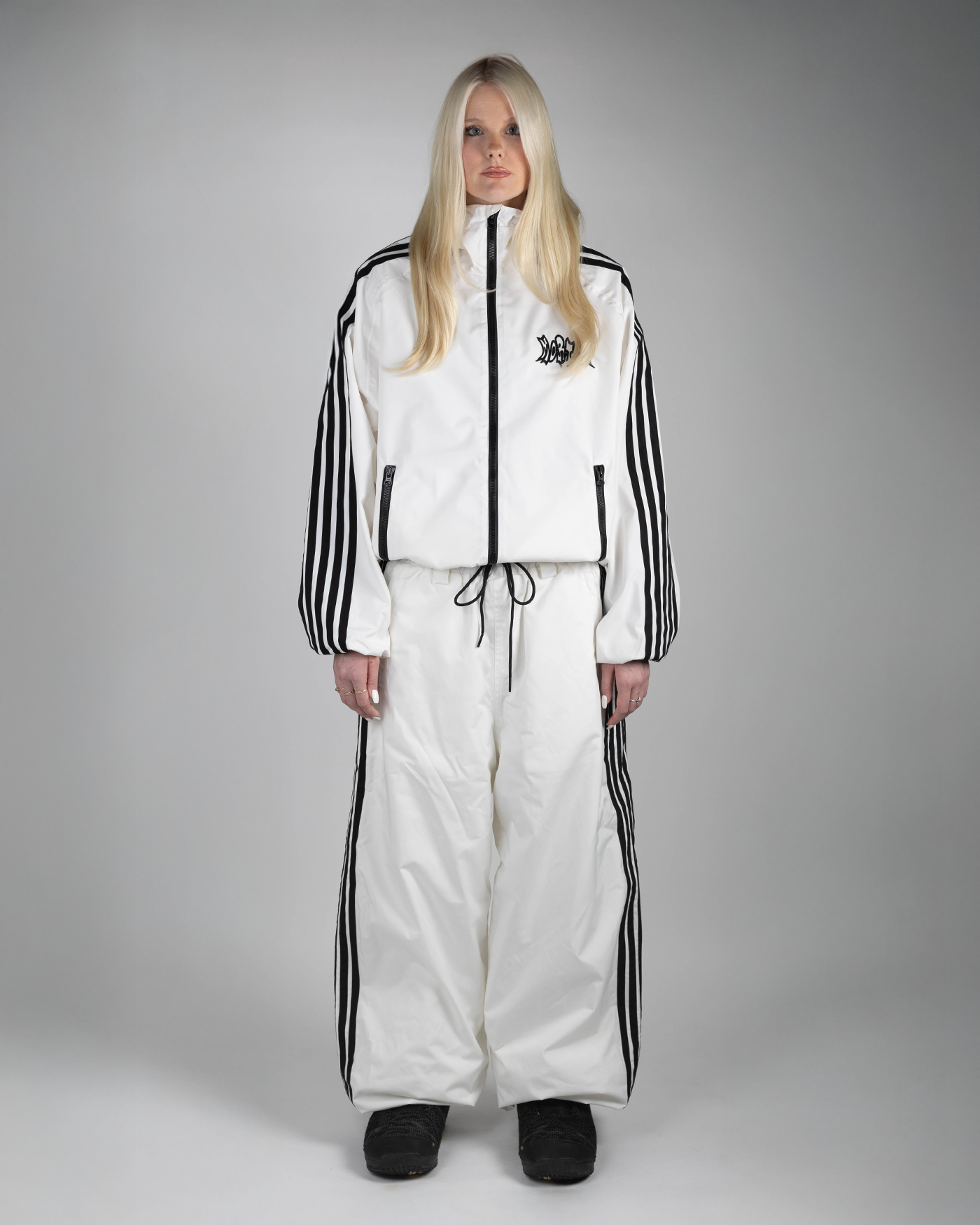 White baggy snowpants full front view on a woman (Hilla is 175cm wearing size L)