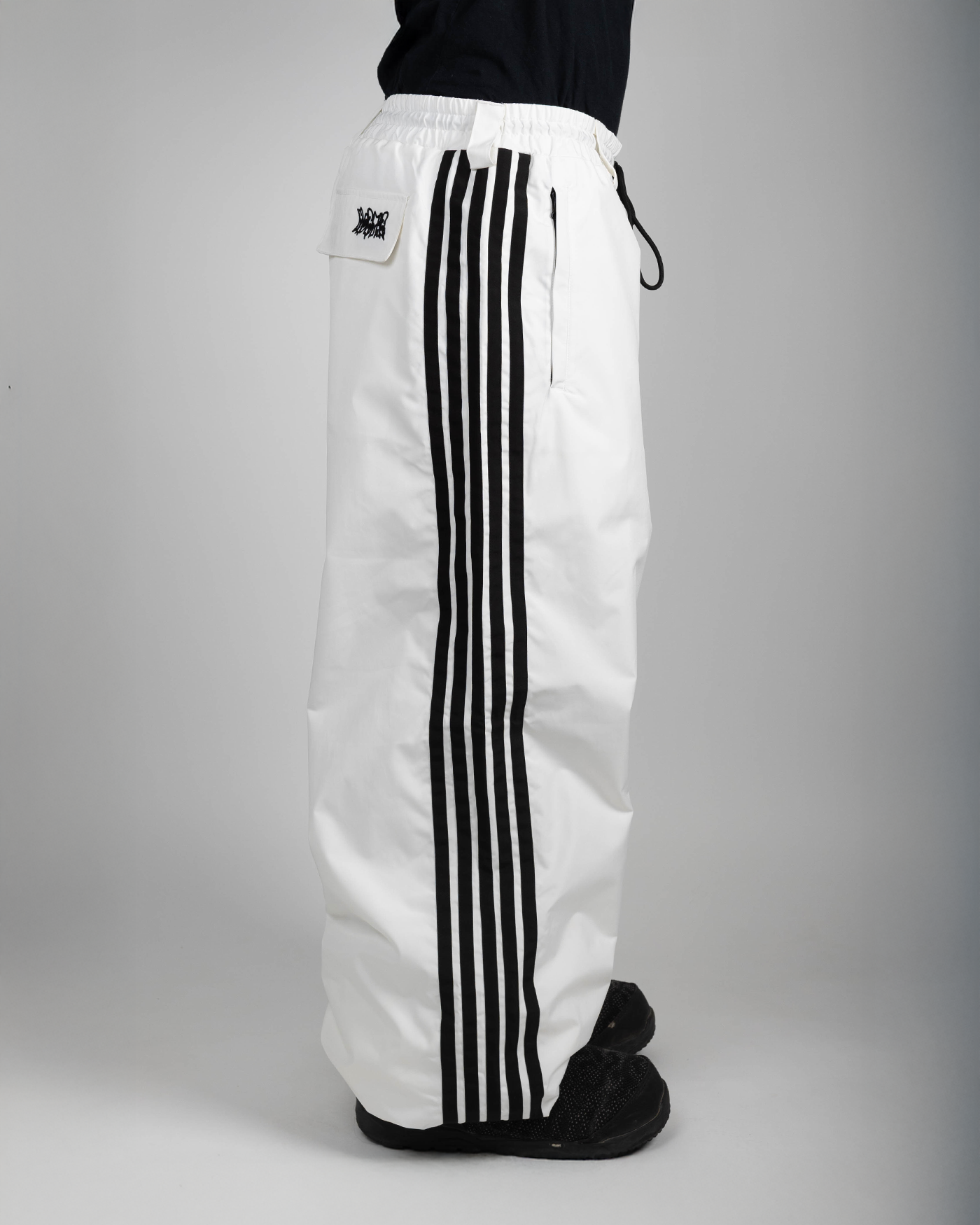 White stripe baggy snowpants side view on model